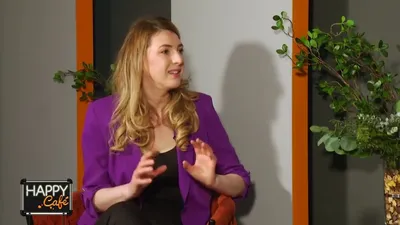 Andreea Giurgilă în sacou mov, vorbind în studioul emisiunii Happy Café