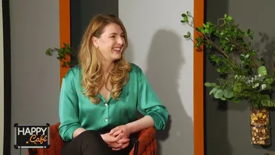 Andreea Giurgilă în cămașă verde, zâmbind, în studioul emisiunii Happy Café