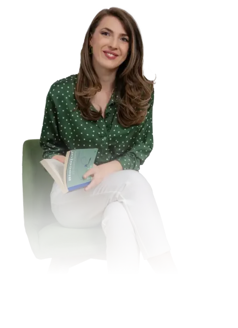Andreea Giurgilă, master NLP, zâmbind, în bluză verde, cu un carnet în mână