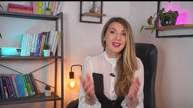Andreea Giurgilă, coach profesionist, în bluză albă, în cabinet, zâmbind și gesticulând, coperta video-ului despre testul DISC